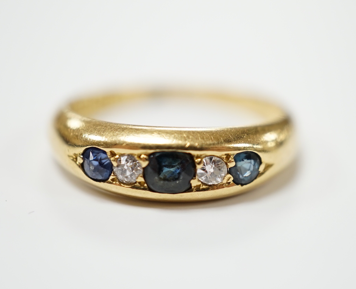 A George V 18ct gold, three stone sapphire and two stone diamond set half hoop ring, size N, gross weight 4 grams.